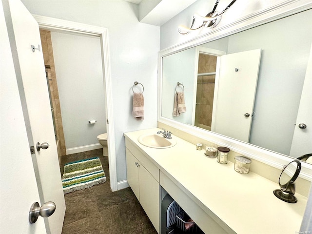 bathroom with vanity, toilet, and a shower