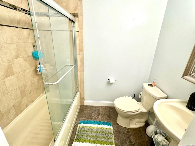 full bathroom featuring shower / bath combination with glass door, toilet, and sink