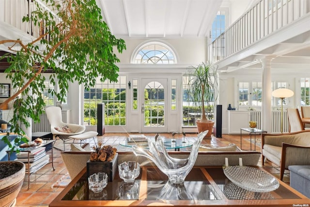 sunroom / solarium featuring vaulted ceiling with beams and ornate columns