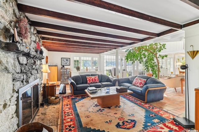 living room with beamed ceiling and a stone fireplace