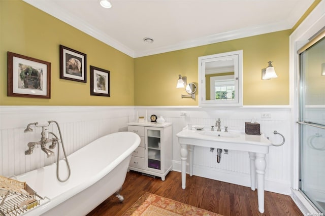 bathroom featuring a tub, ornamental molding, and hardwood / wood-style flooring