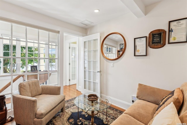 living room with beam ceiling and light hardwood / wood-style floors