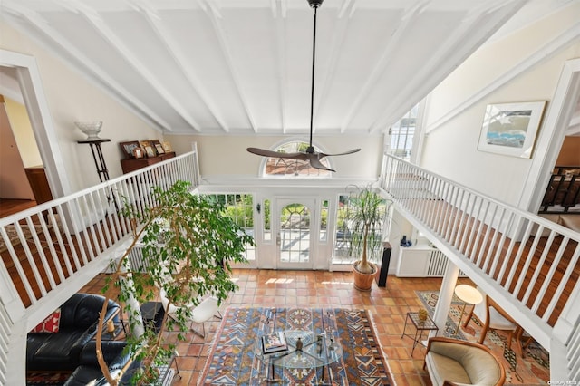 interior space featuring beam ceiling and a high ceiling