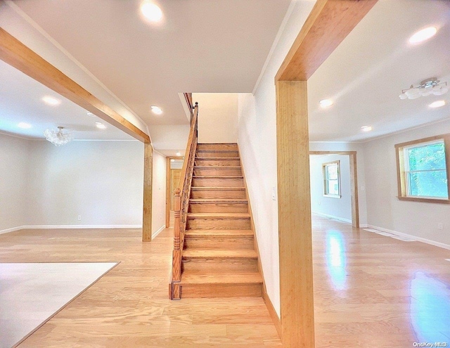 staircase with hardwood / wood-style floors and ornamental molding