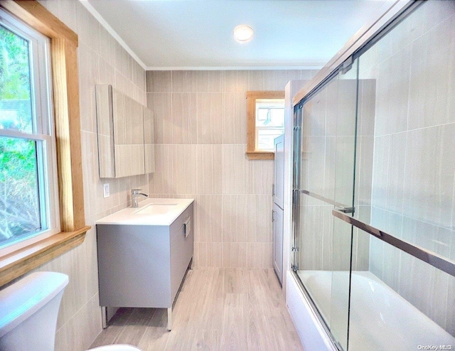 full bathroom featuring hardwood / wood-style flooring, toilet, and tile walls