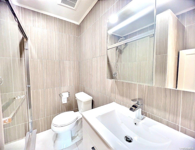 bathroom featuring vanity, toilet, and tile walls