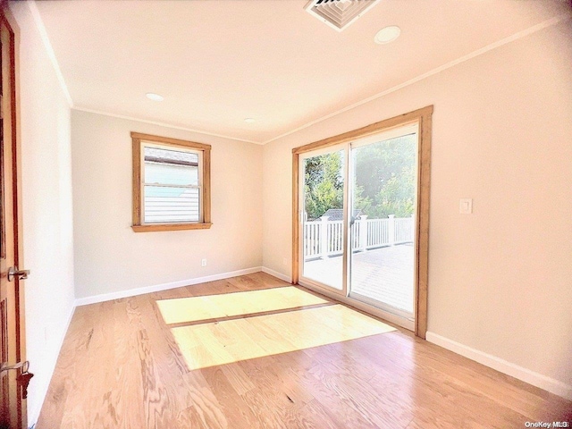 spare room featuring wood-type flooring and ornamental molding