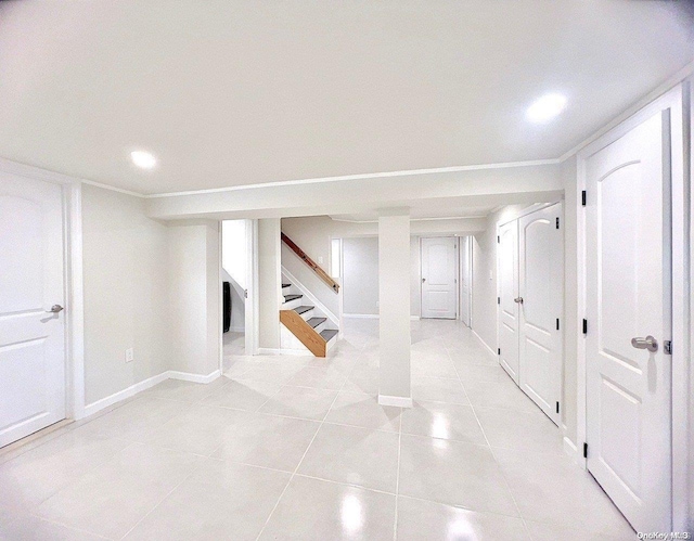 basement with light tile patterned flooring and crown molding