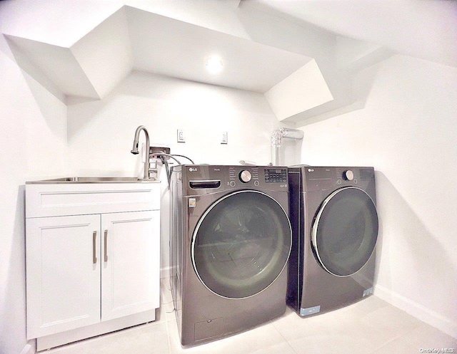 clothes washing area featuring cabinets, light tile patterned floors, washer and clothes dryer, and sink