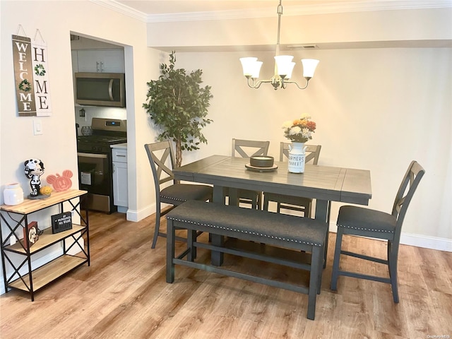 dining area with crown molding, visible vents, baseboards, light wood-style floors, and an inviting chandelier