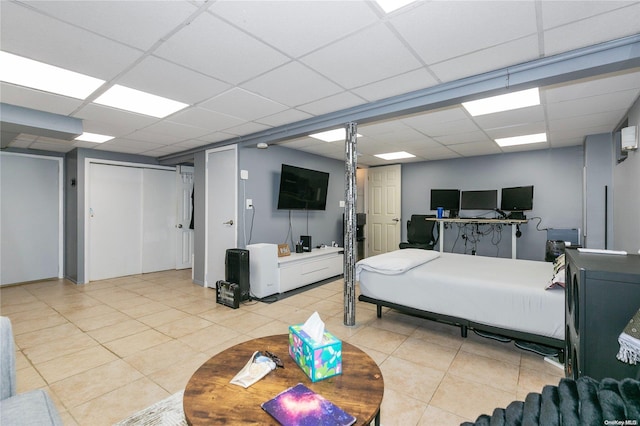 bedroom featuring light tile patterned floors and a drop ceiling