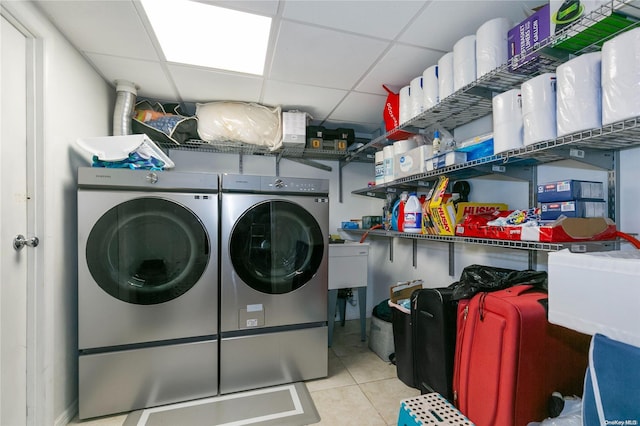 laundry area with independent washer and dryer and light tile patterned floors