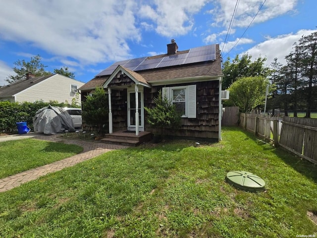 view of front of house featuring a front yard and solar panels