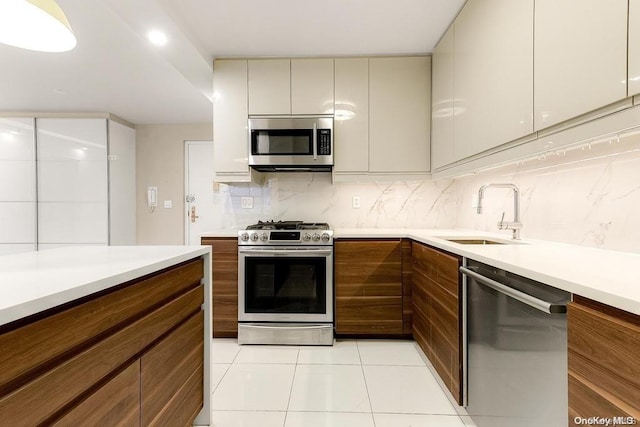 kitchen featuring backsplash, sink, light tile patterned flooring, and appliances with stainless steel finishes