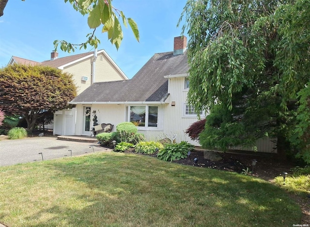 21 Piper Ln, Levittown, NY 11756 - view of front of house with a front lawn, a chimney, and roof with shingles
