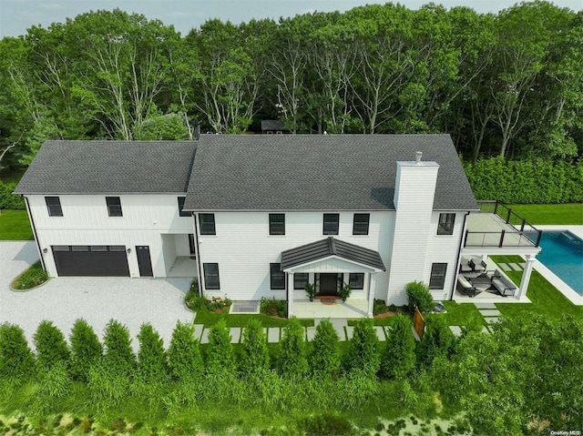 66 Peters Ln, Westhampton Beach, NY 11978 - view of front of house with a chimney, a patio area, an attached garage, an outdoor pool, and a gazebo