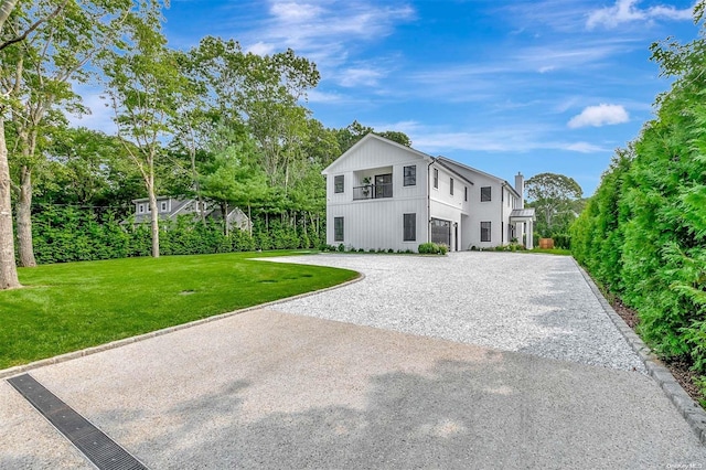 66 Peters Ln, Westhampton Beach, NY 11978 - view of front facade featuring curved driveway, a front lawn, and a garage
