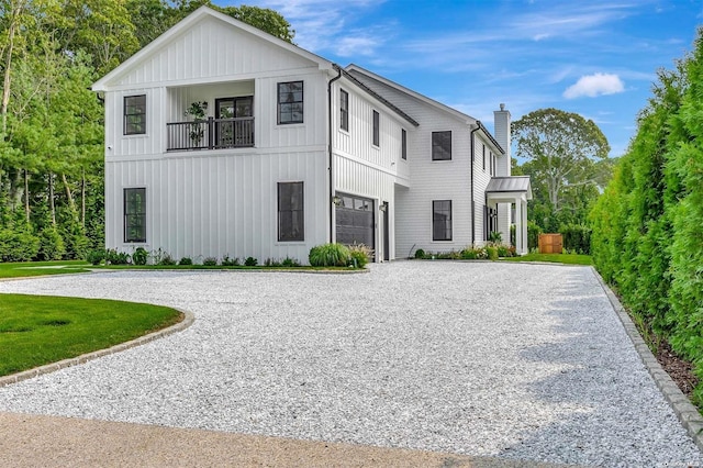 66 Peters Ln, Westhampton Beach, NY 11978 - modern farmhouse with curved driveway, a garage, a balcony, a chimney, and board and batten siding