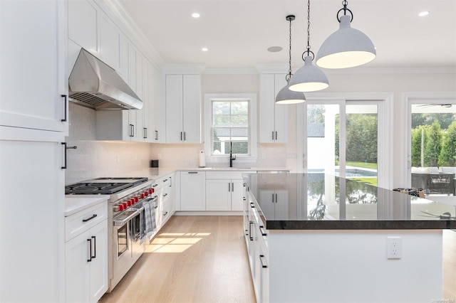 kitchen featuring extractor fan, decorative light fixtures, white cabinets, double oven range, and crown molding