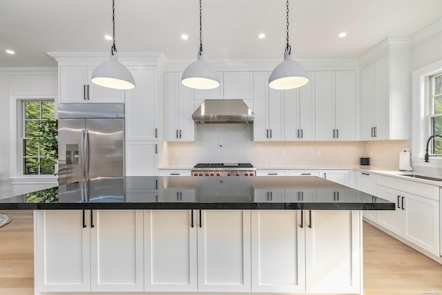 kitchen featuring stainless steel built in refrigerator, a kitchen island, white cabinets, and extractor fan