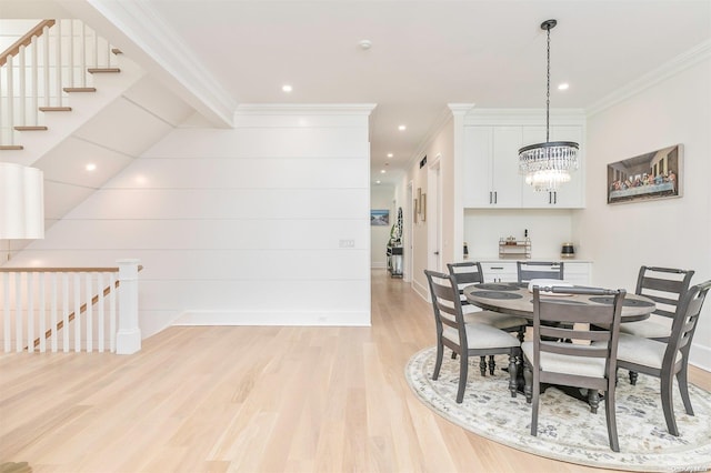 dining area featuring a notable chandelier, ornamental molding, and light wood-type flooring