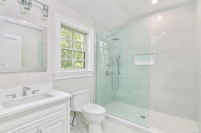 bathroom featuring vanity, toilet, and a tile shower