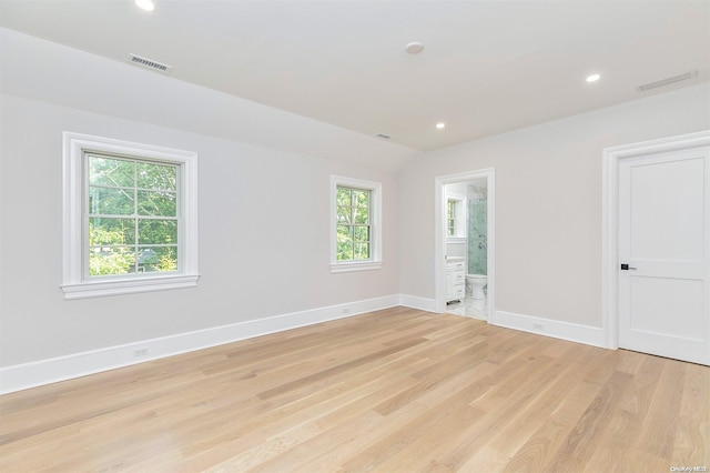 empty room featuring lofted ceiling and light hardwood / wood-style floors