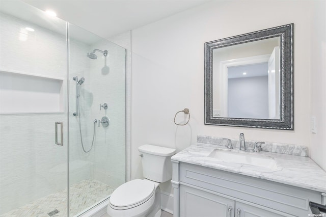 bathroom with walk in shower, vanity, and toilet