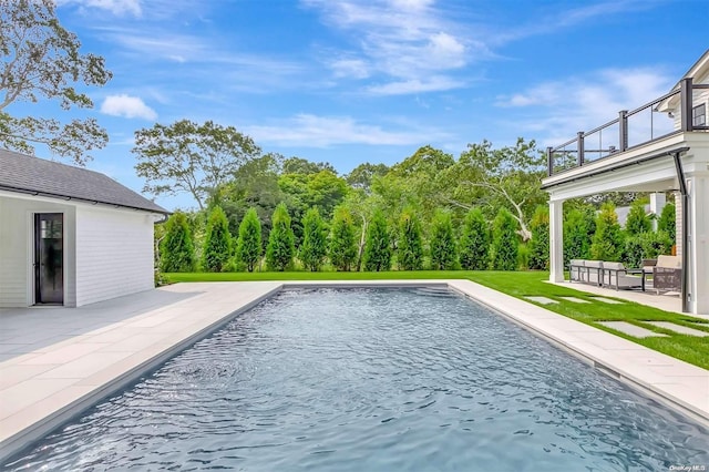 view of swimming pool featuring a yard and a patio