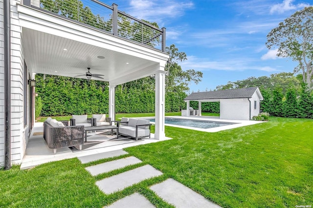 view of yard featuring a balcony, an outbuilding, ceiling fan, an outdoor hangout area, and a patio