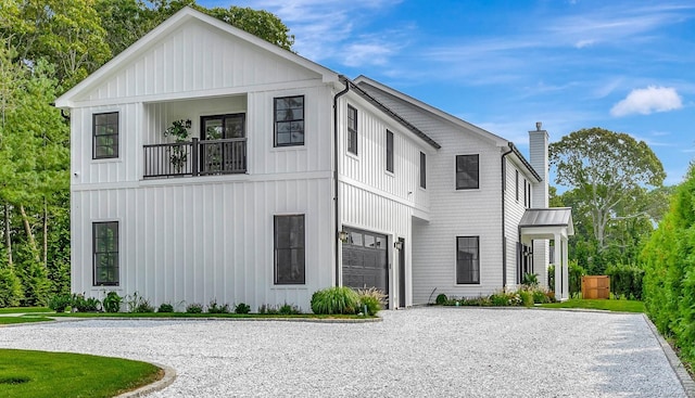 modern farmhouse style home featuring a garage and a balcony