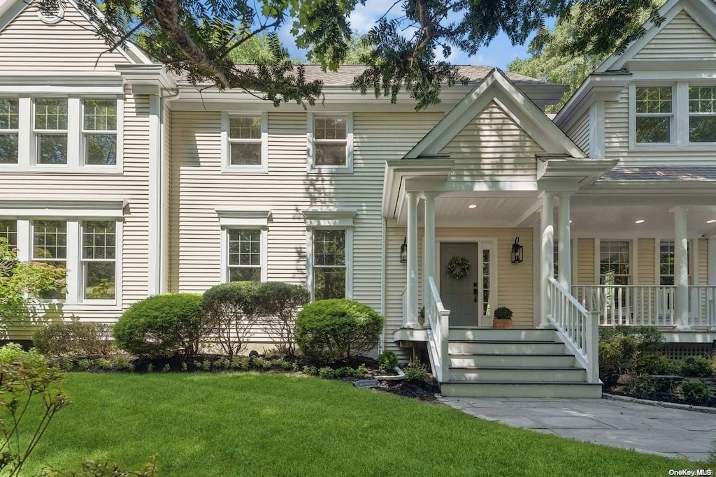 view of front of house with a porch and a front lawn