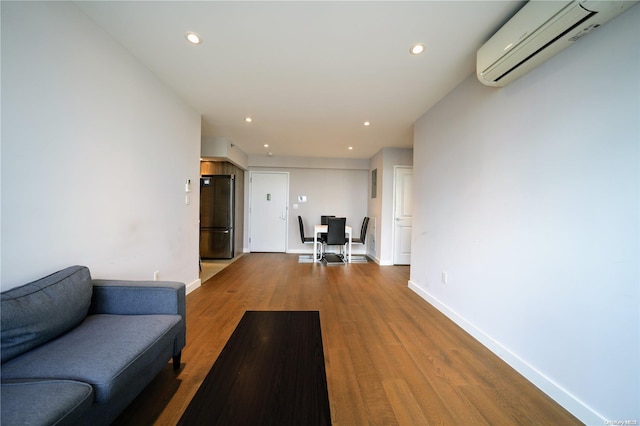 living room featuring wood-type flooring and a wall mounted AC