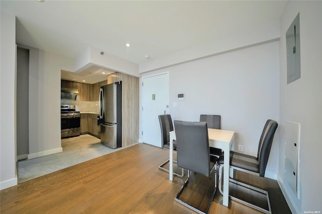 dining room with electric panel and light hardwood / wood-style floors