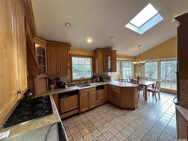 kitchen featuring backsplash, a wealth of natural light, paneled dishwasher, and lofted ceiling with skylight