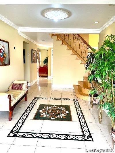 corridor featuring tile patterned flooring and crown molding