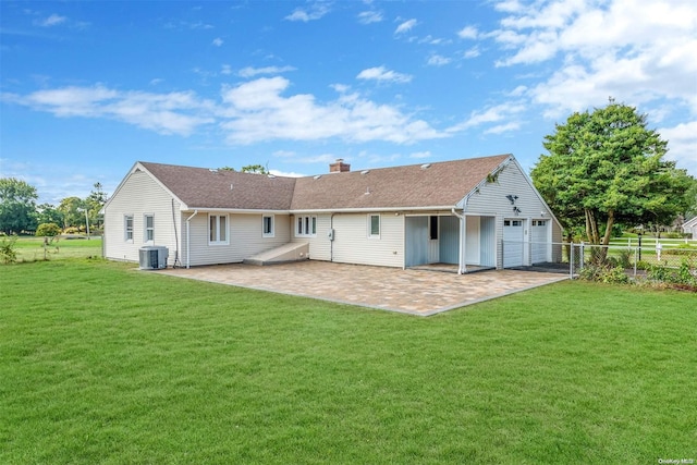 back of property featuring a lawn, a garage, and central air condition unit