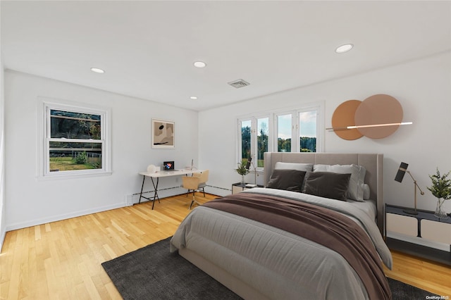 bedroom with wood-type flooring and a baseboard radiator