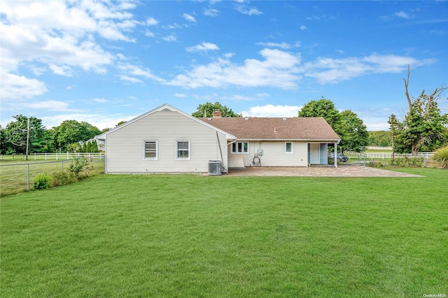 back of property featuring a patio area, a yard, and central AC