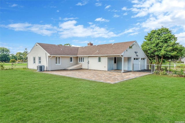 rear view of property with a lawn, a garage, and central air condition unit