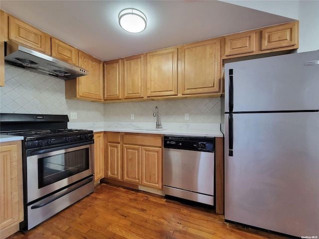 kitchen featuring sink, stainless steel appliances, light hardwood / wood-style flooring, and range hood