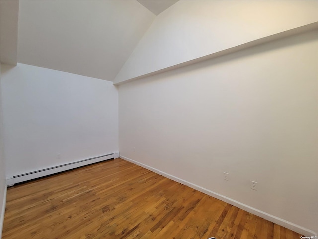 bonus room featuring hardwood / wood-style flooring, lofted ceiling, and a baseboard heating unit