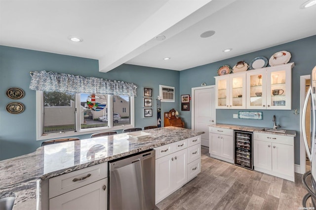 kitchen with light stone countertops, light wood-type flooring, stainless steel dishwasher, white cabinets, and wine cooler