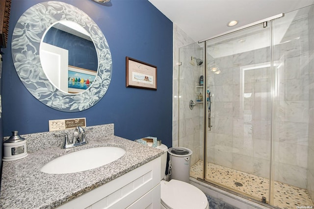 bathroom with vanity, a shower with shower door, and toilet