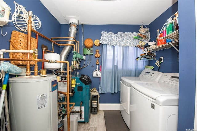 clothes washing area featuring hardwood / wood-style floors, washer and clothes dryer, and gas water heater