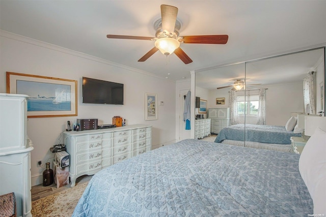 bedroom with ceiling fan, a closet, light wood-type flooring, and ornamental molding