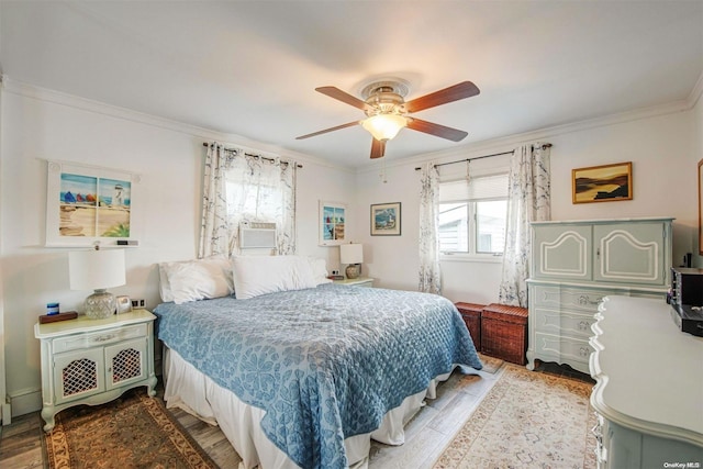 bedroom with hardwood / wood-style floors, cooling unit, ceiling fan, and crown molding