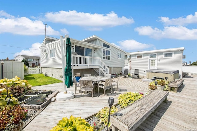 back of house with a wooden deck and a hot tub