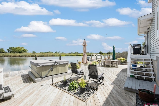 deck featuring a water view and a hot tub