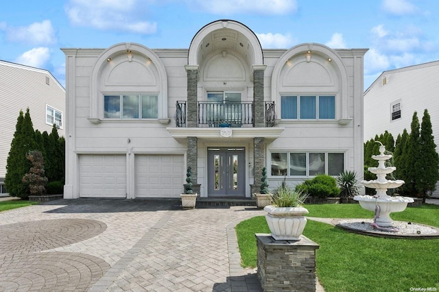 view of front of home featuring a balcony, a front lawn, and a garage